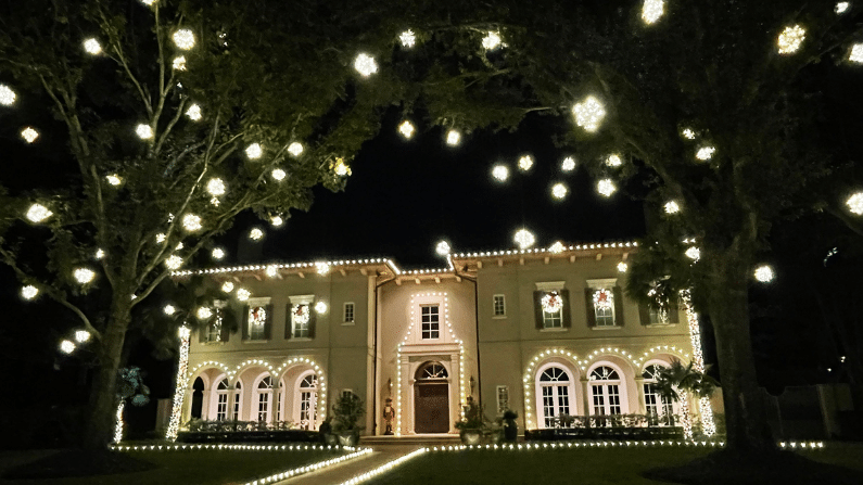 Simple, all white, sparking Christmas lights on a white house
